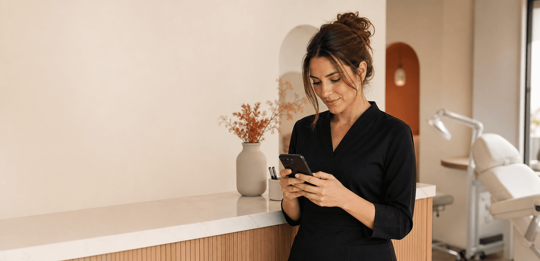 Propietaria de un estudio de micropigmentación revisando mensajes en su teléfono
